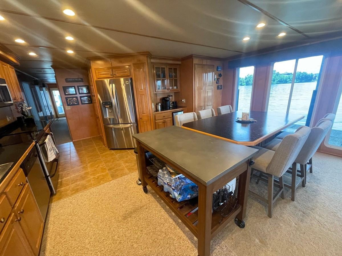 a large kitchen and dining area aboard 2005 HORIZON 18X88 HOUSEBOAT Yacht for Sale