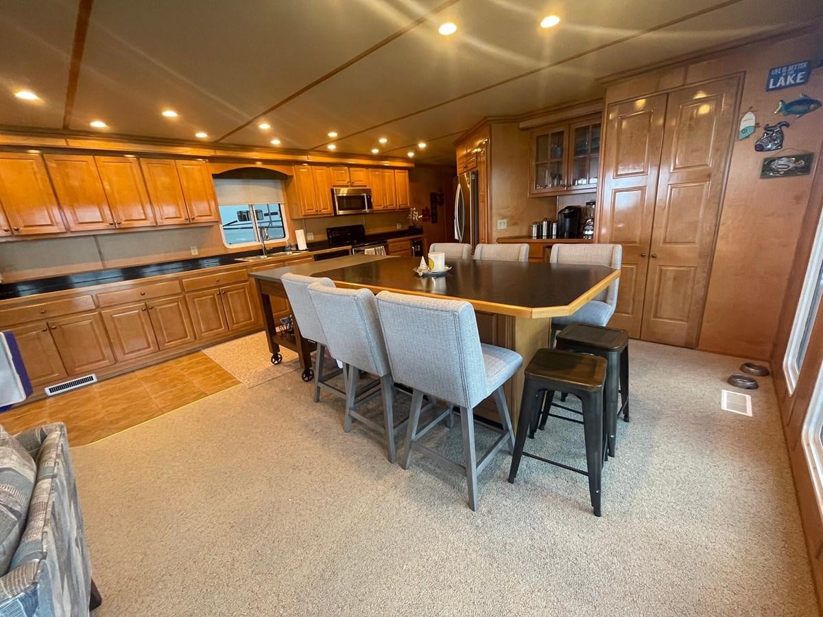 a large kitchen with wooden cabinets aboard 2005 HORIZON 18X88 HOUSEBOAT Yacht for Sale