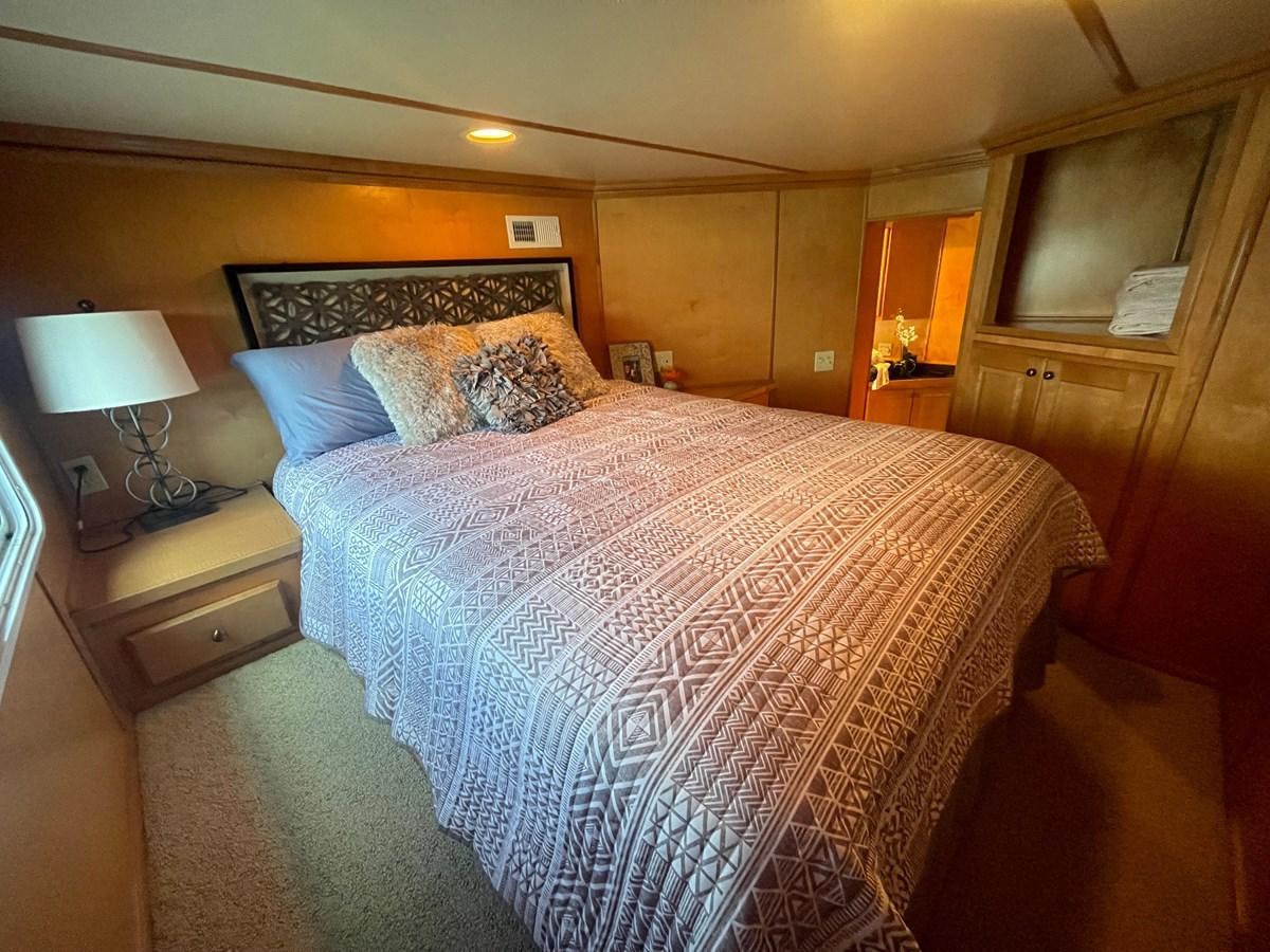 a bed with a lamp on it aboard 2005 HORIZON 18X88 HOUSEBOAT Yacht for Sale