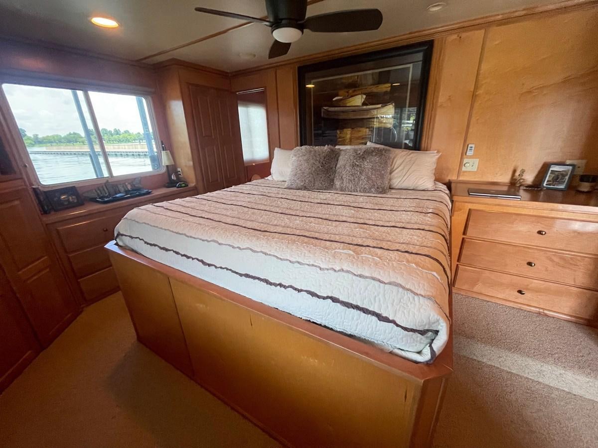 a bedroom with a bed and a television aboard 2005 HORIZON 18X88 HOUSEBOAT Yacht for Sale