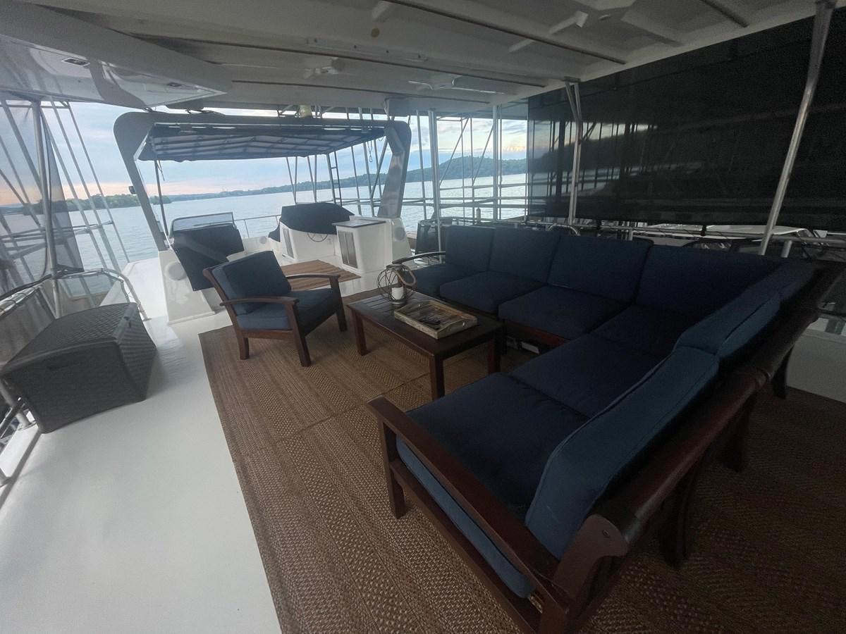 a room with a couch and a table aboard 2005 HORIZON 18X88 HOUSEBOAT Yacht for Sale