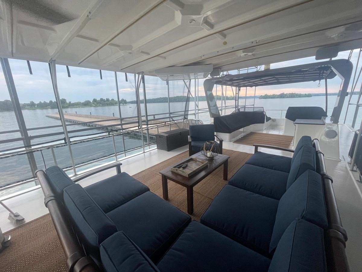 inside of a vehicle with a table and chairs and a large window aboard 2005 HORIZON 18X88 HOUSEBOAT Yacht for Sale