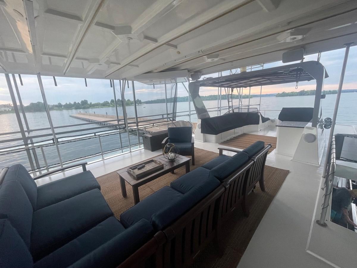 a room with a couch and a table and a tv aboard 2005 HORIZON 18X88 HOUSEBOAT Yacht for Sale