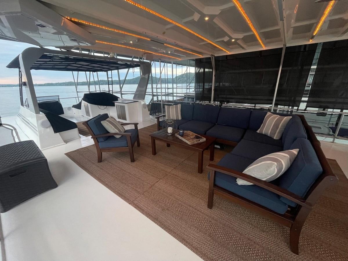 a room with a couch and a table aboard 2005 HORIZON 18X88 HOUSEBOAT Yacht for Sale