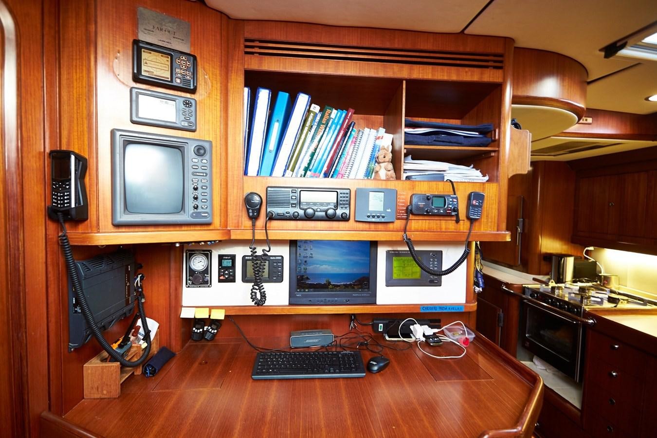 a computer desk with a television and a book shelf aboard FAR OUT Yacht for Sale