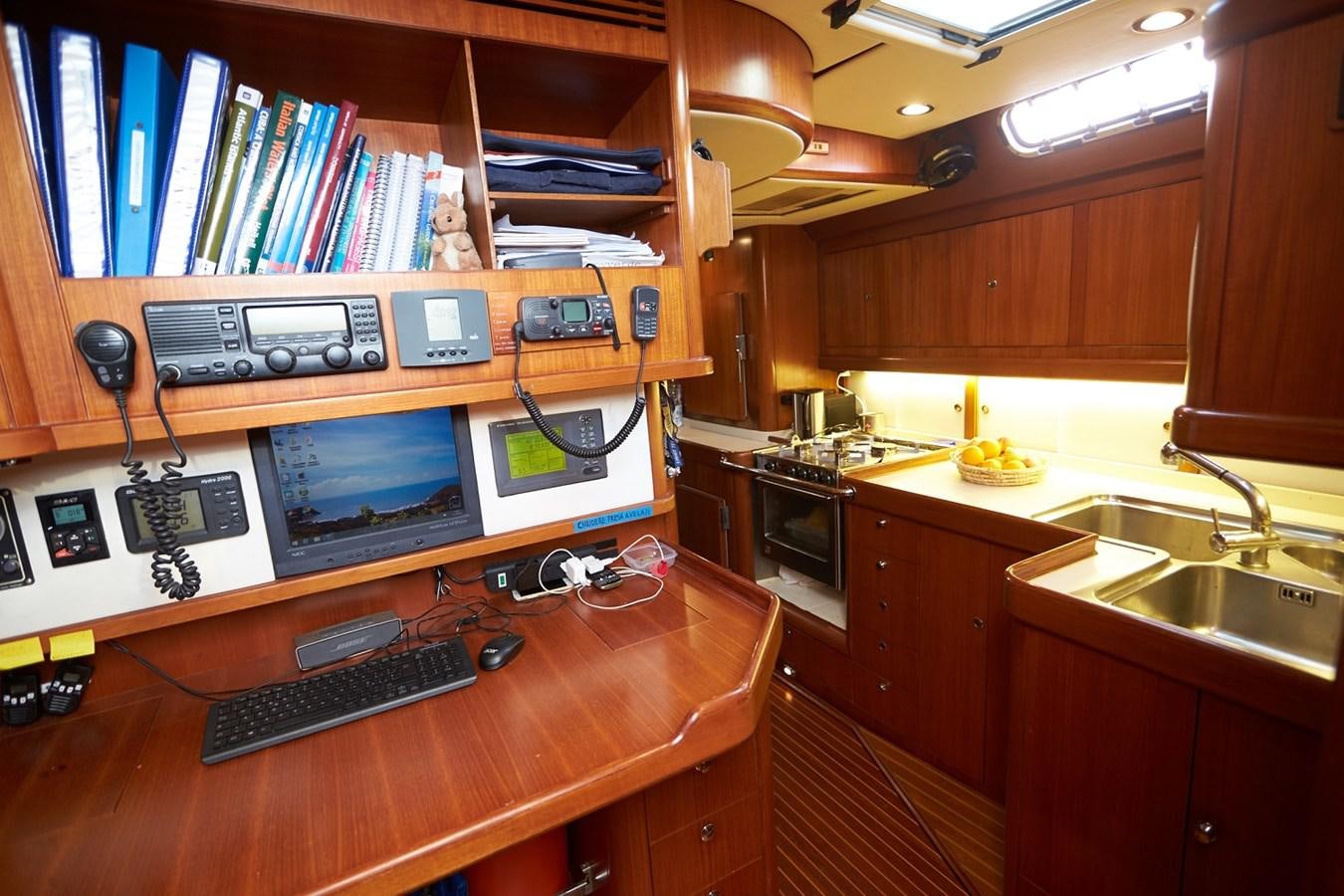 a computer desk with a computer and other electronics on it aboard FAR OUT Yacht for Sale