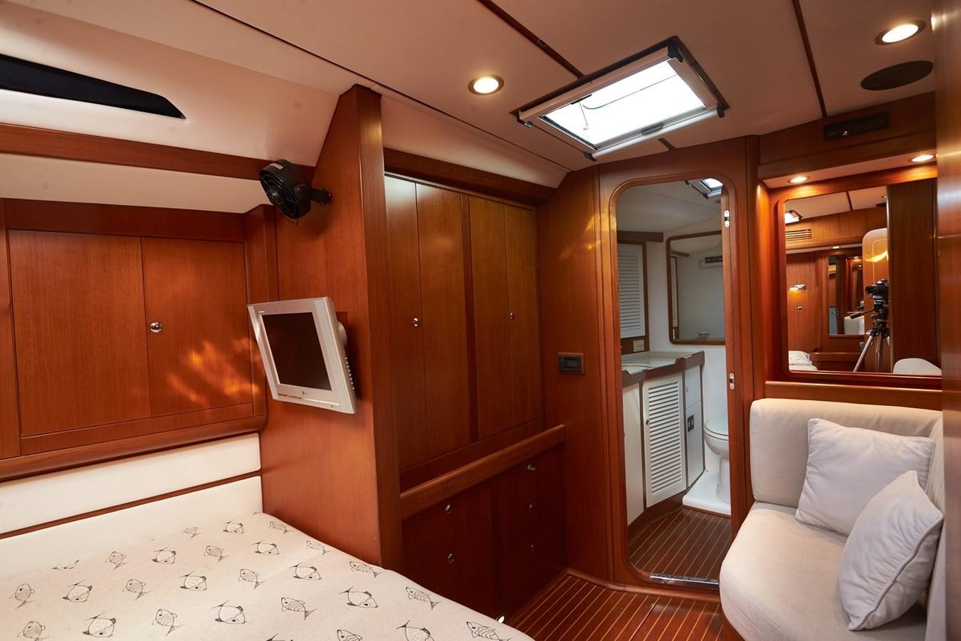 a bedroom with a bed and a television aboard FAR OUT Yacht for Sale