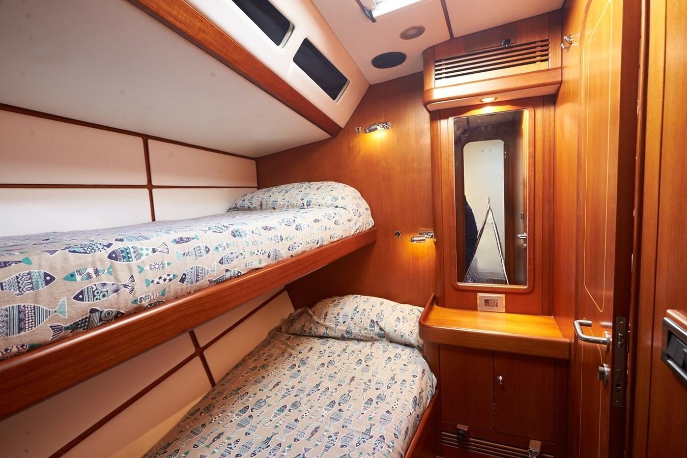 a bedroom with a bed and a mirror aboard FAR OUT Yacht for Sale