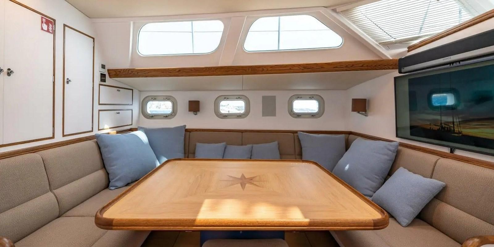 a couch with a table and a television in a room aboard ALTAIR Yacht for Sale