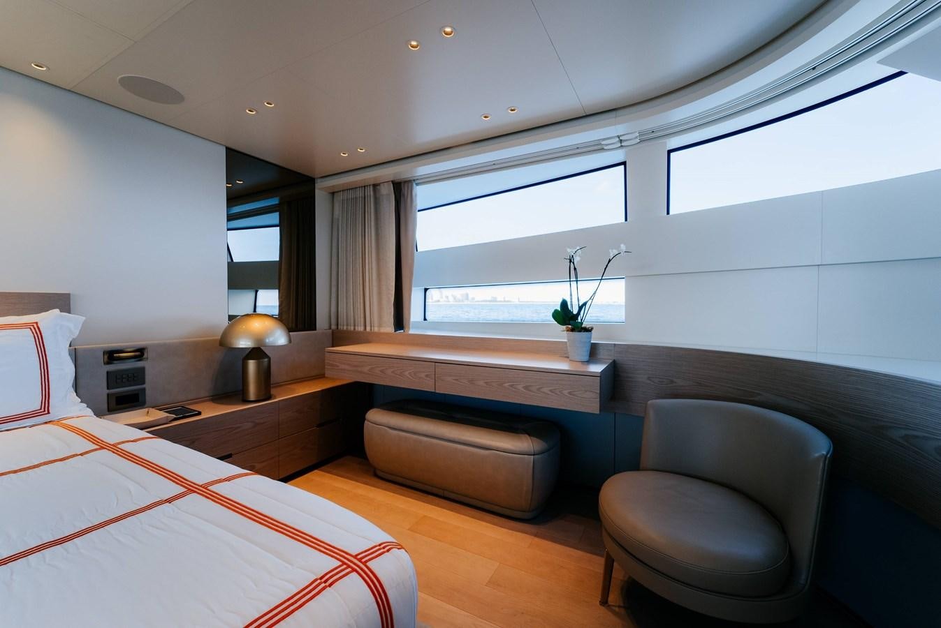 a bedroom with a bed and a desk aboard PEARL Yacht for Sale