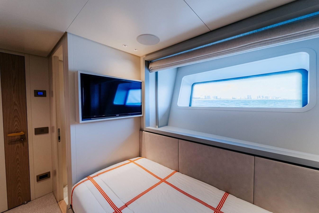 a room with a bed and a tv on the wall aboard PEARL Yacht for Sale