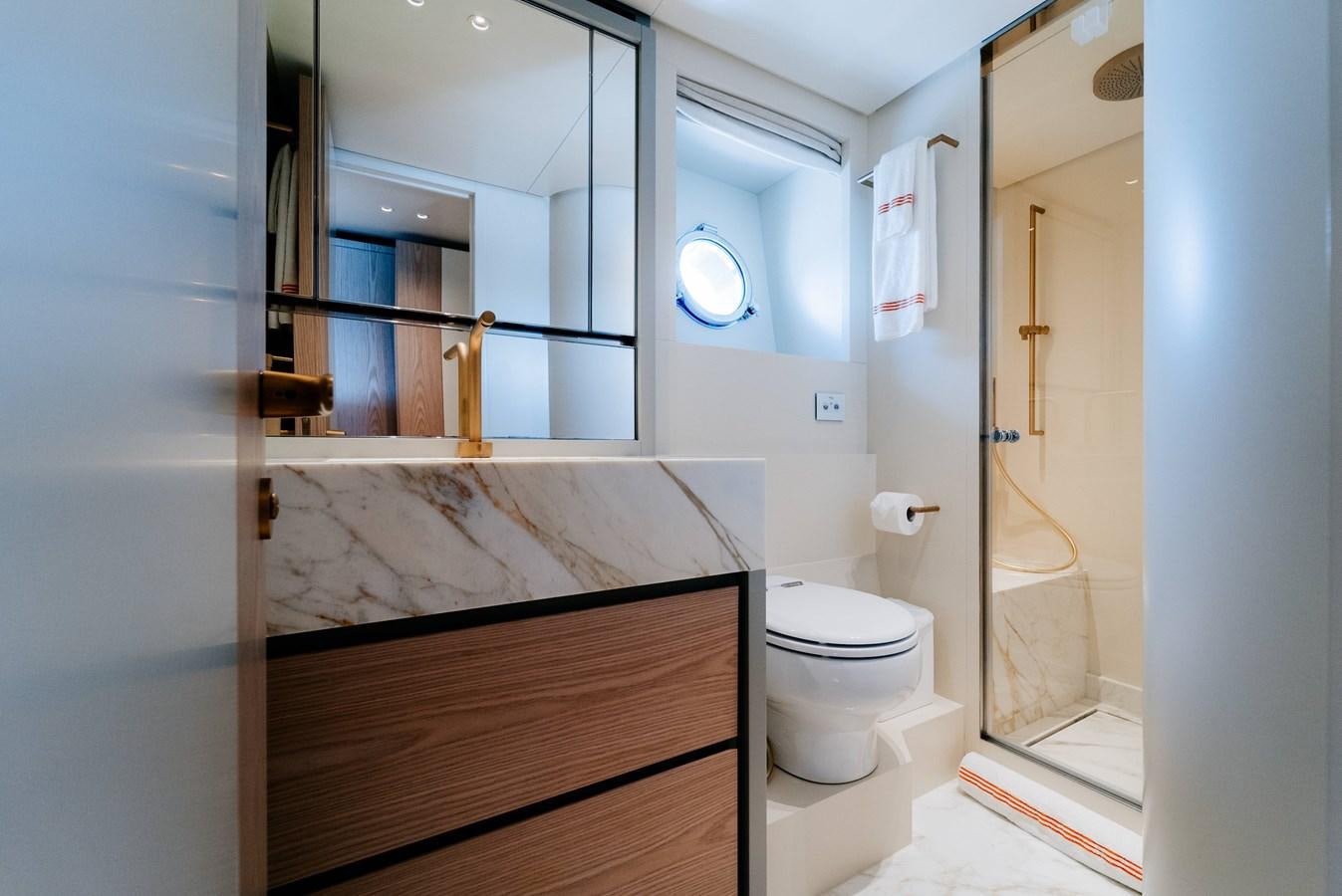 a bathroom with a toilet and a mirror aboard PEARL Yacht for Sale