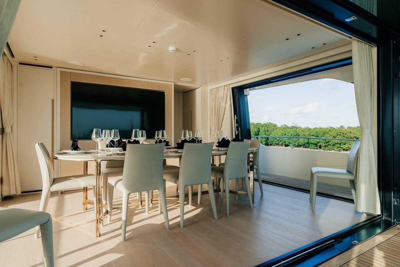 a room with a table chairs and a tv aboard PEARL Yacht for Sale