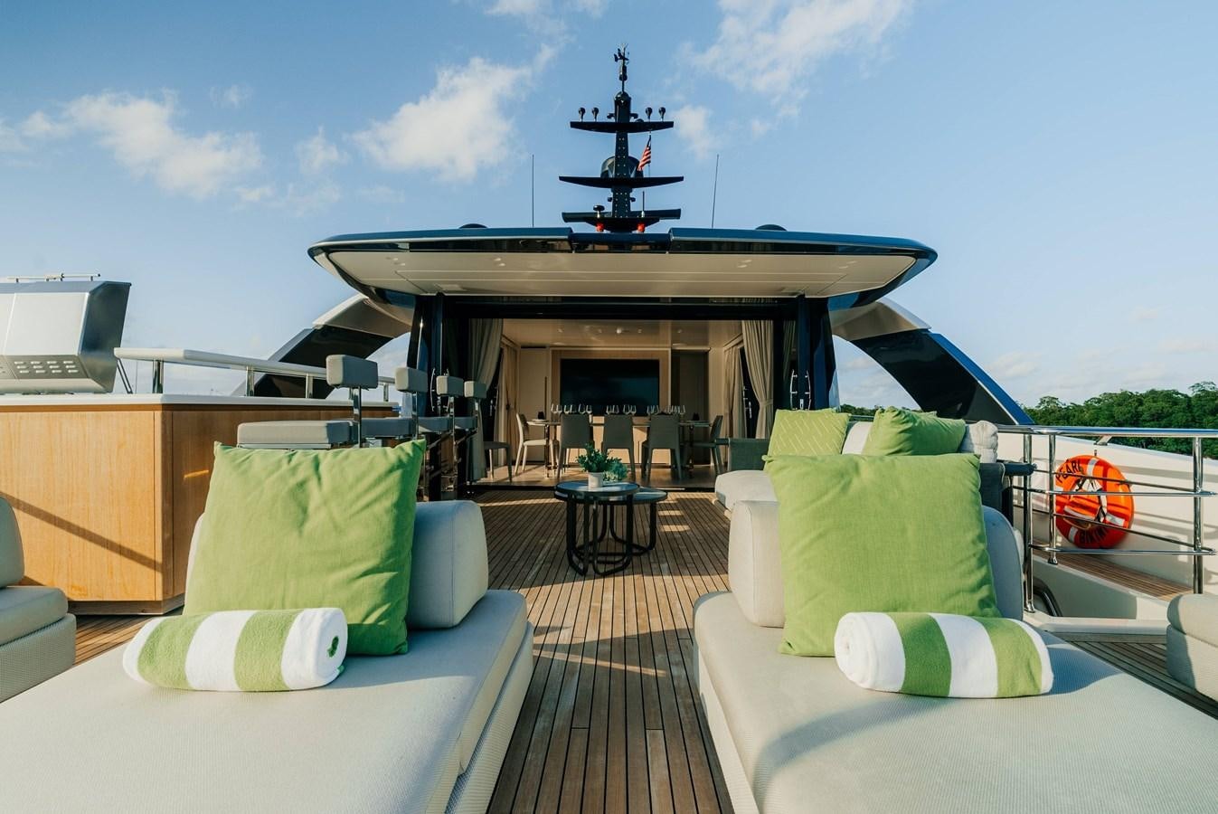 a room with a couch and a fireplace and a large ship in the background aboard PEARL Yacht for Sale