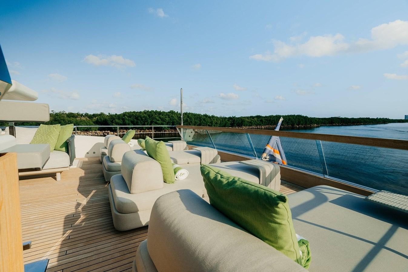 a deck with a view of a lake and a large boat aboard PEARL Yacht for Sale