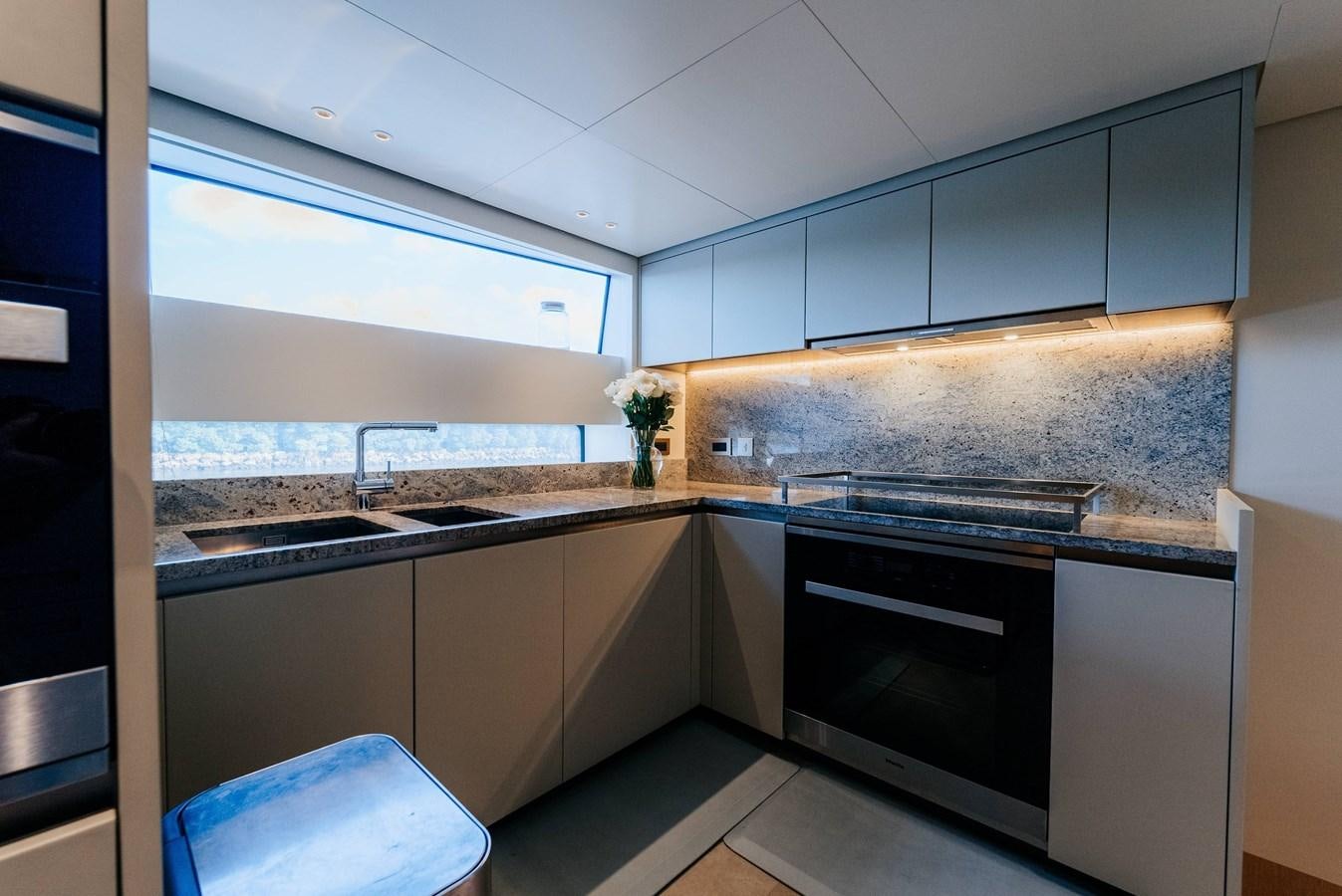 a kitchen with a black stove aboard PEARL Yacht for Sale