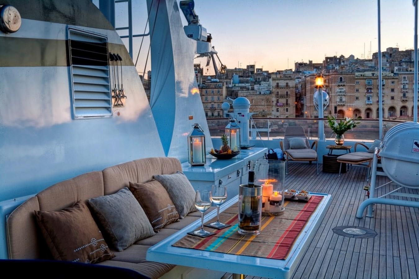 a room with a couch and a table with a glass of beer on it aboard SANSSOUCI STAR Yacht for Sale