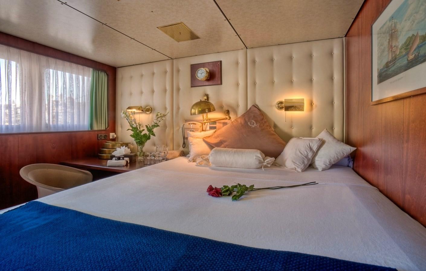 a bed with a blue sheet aboard SANSSOUCI STAR Yacht for Sale