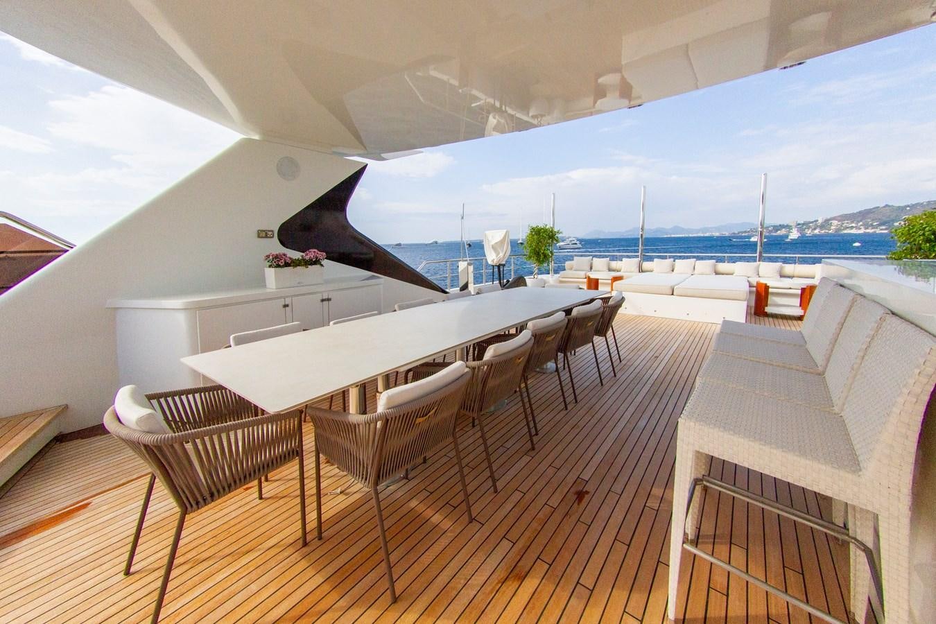 a room with a table chairs and a large window with a view of the water aboard DARLING Yacht for Sale