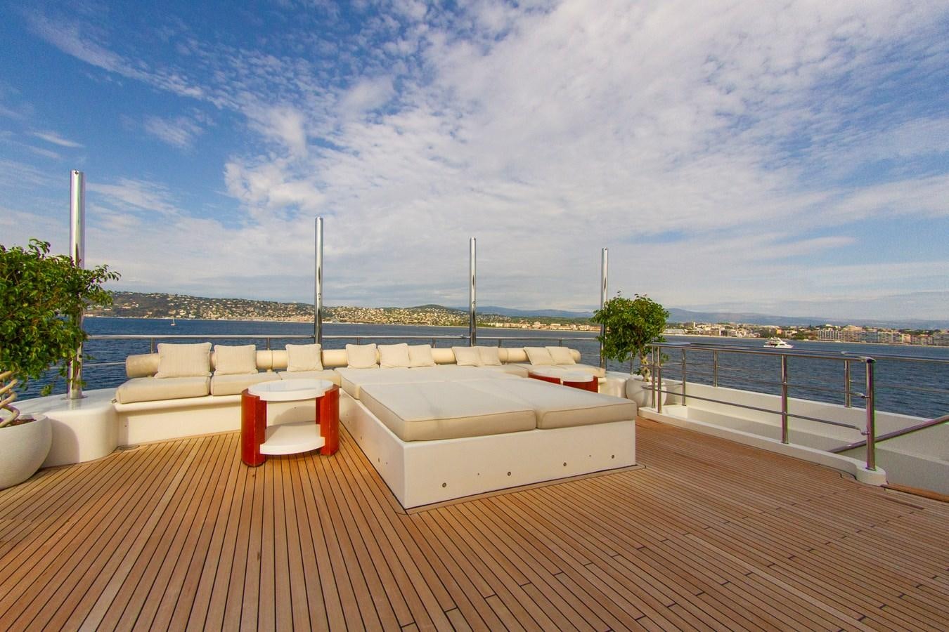 a deck with a bench and tables aboard DARLING Yacht for Sale