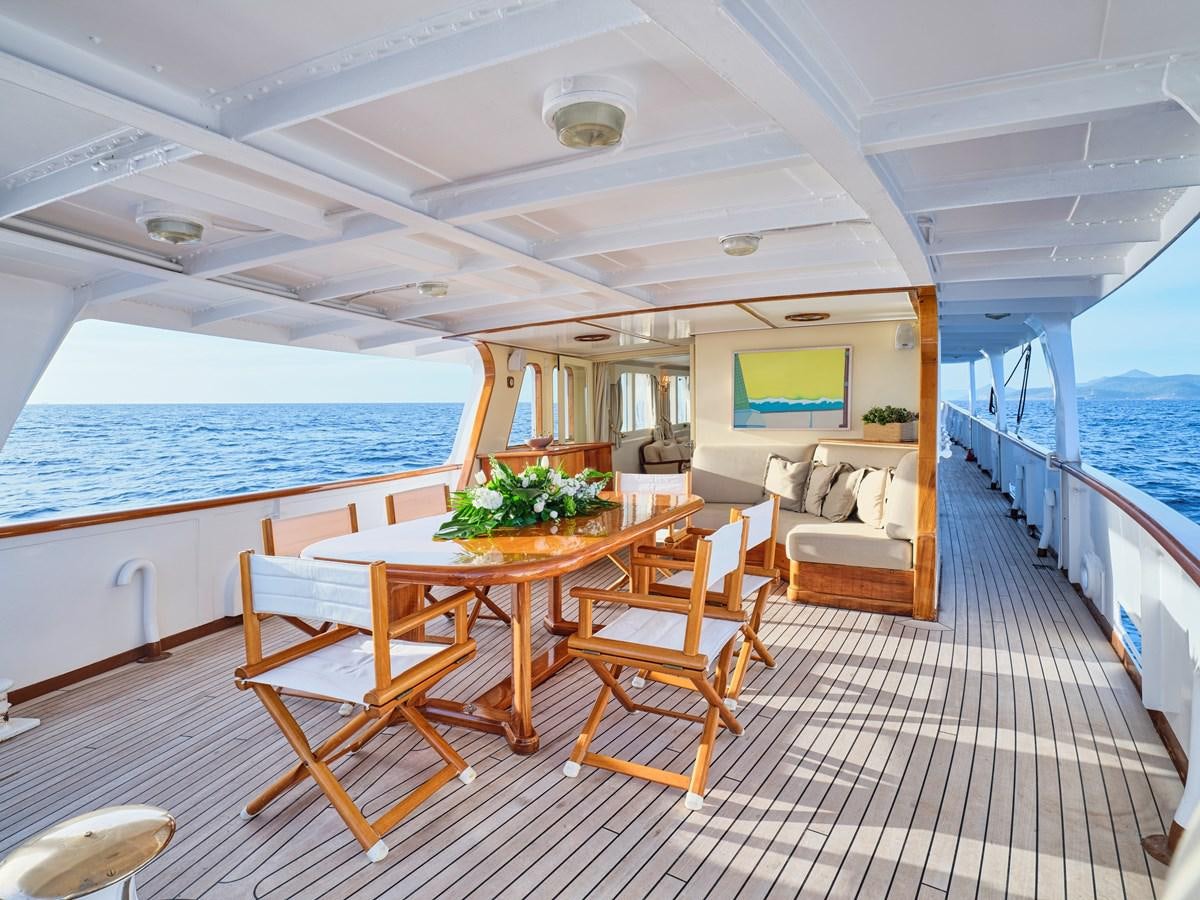 a boat with a table and chairs aboard MIDNIGHT SUN Yacht for Sale