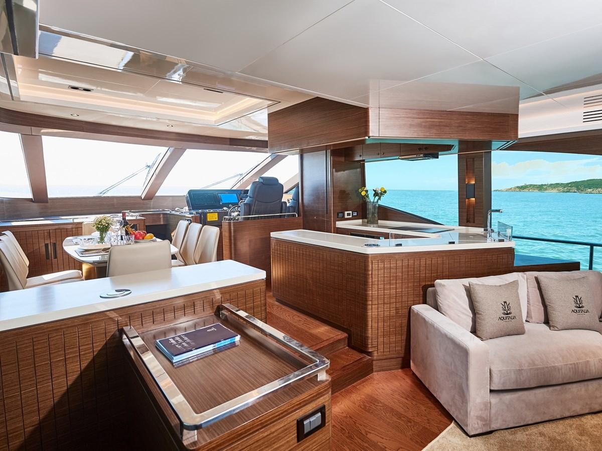 a room with a couch and a table and a large window aboard DIVA RITA Yacht for Sale