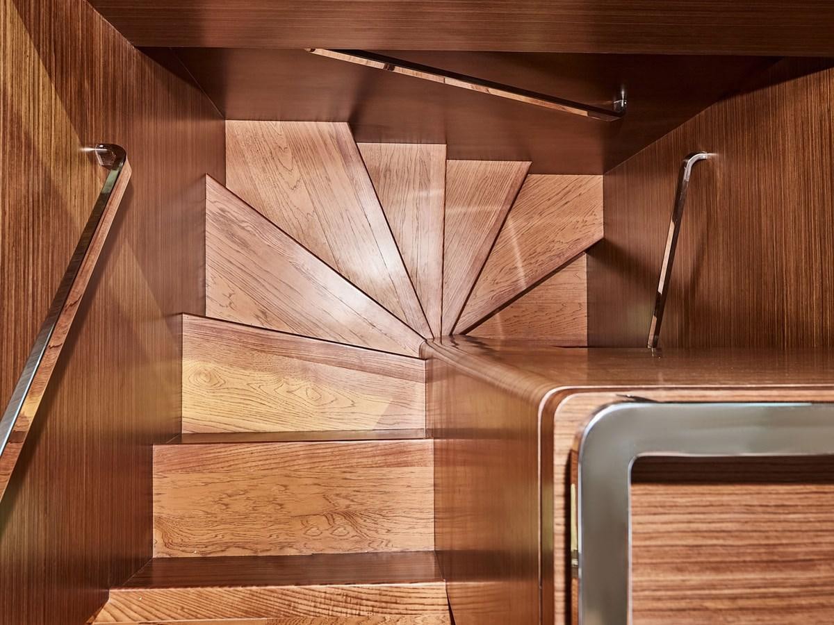 a wooden staircase with a railing aboard DIVA RITA Yacht for Sale