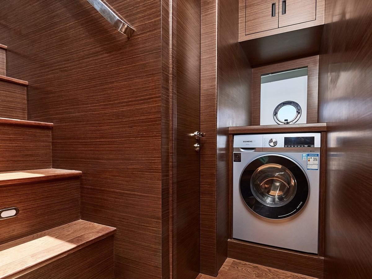 a washer and dryer in a wooden room aboard DIVA RITA Yacht for Sale