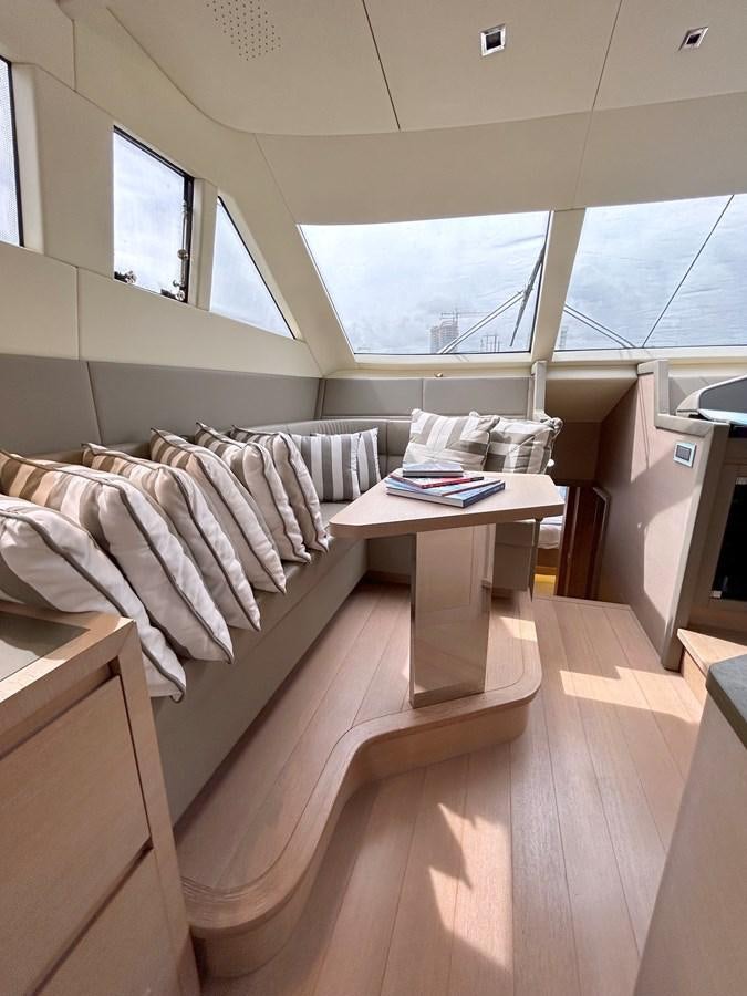a bed with a desk in a room with a window aboard KIND OF BLUE Yacht for Sale