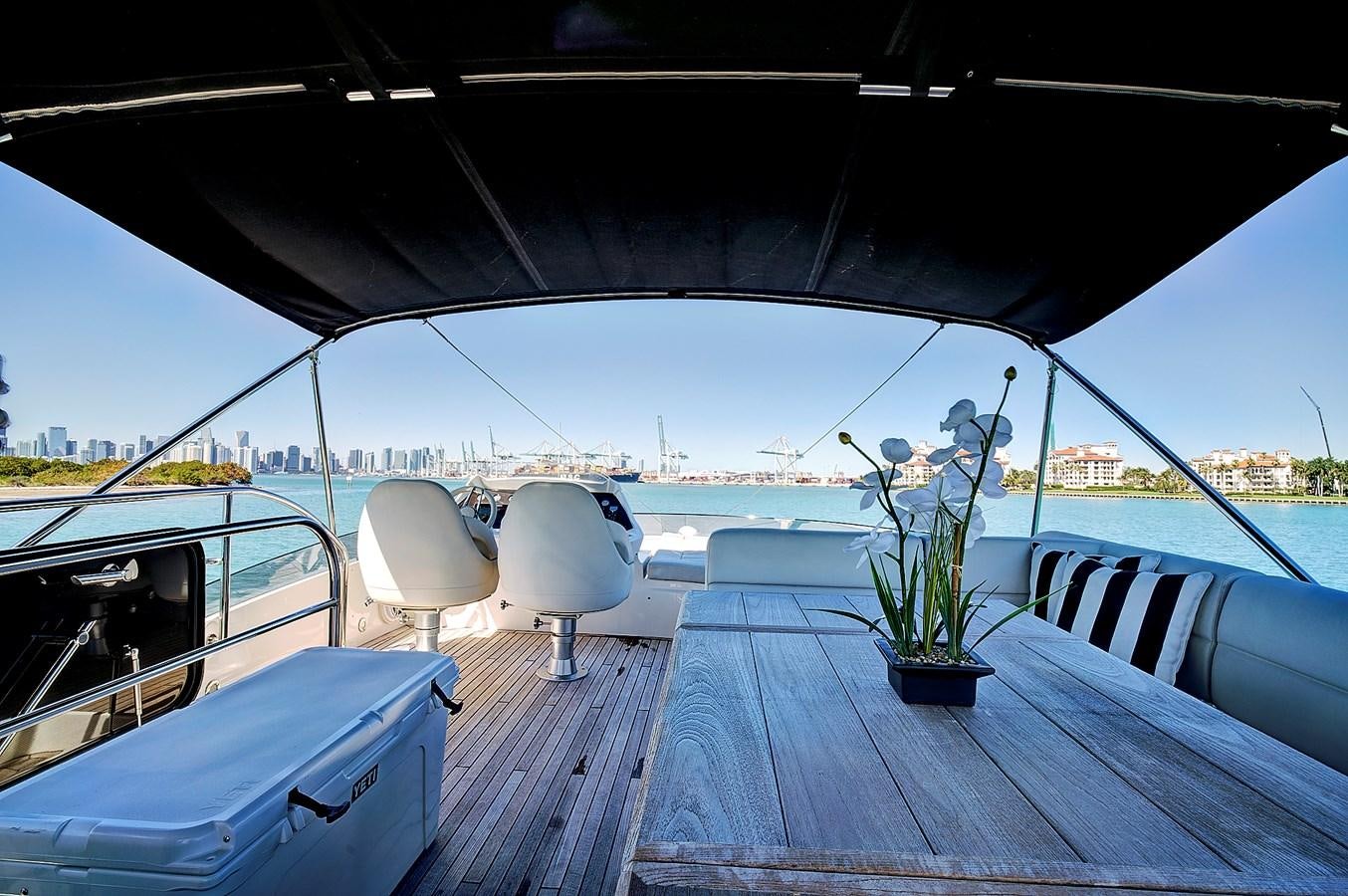 a table on a deck with chairs and plants on it aboard KING Yacht for Sale