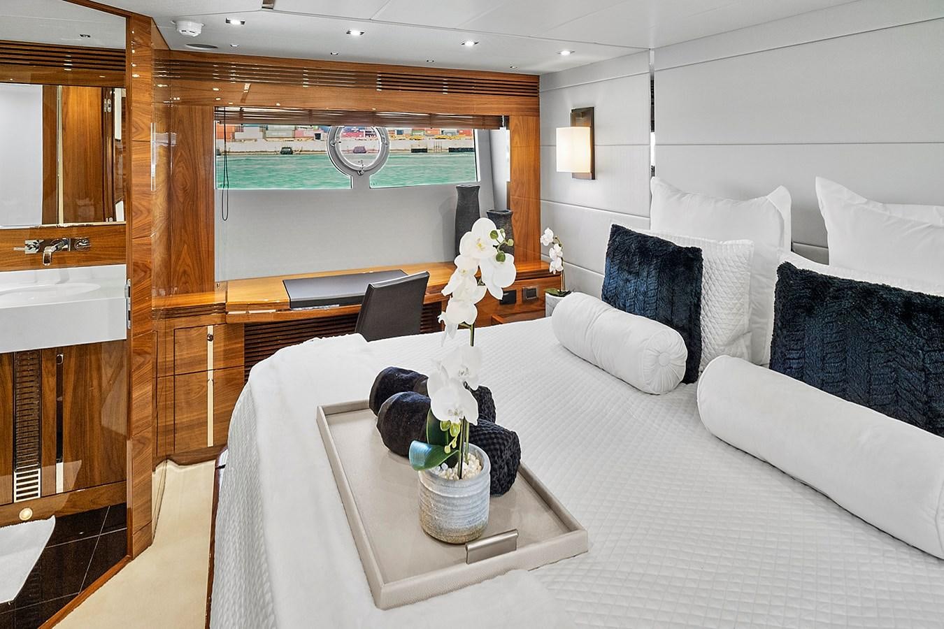 a room with a bed and a table with white pillows aboard KING Yacht for Sale