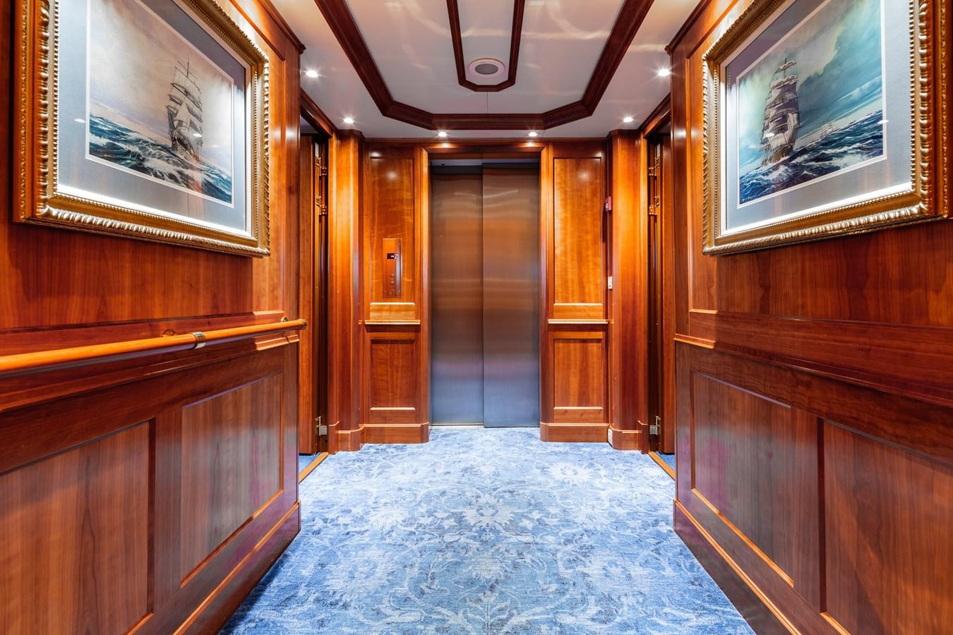 a room with wood cabinets and a rug aboard CUPANI Yacht for Sale