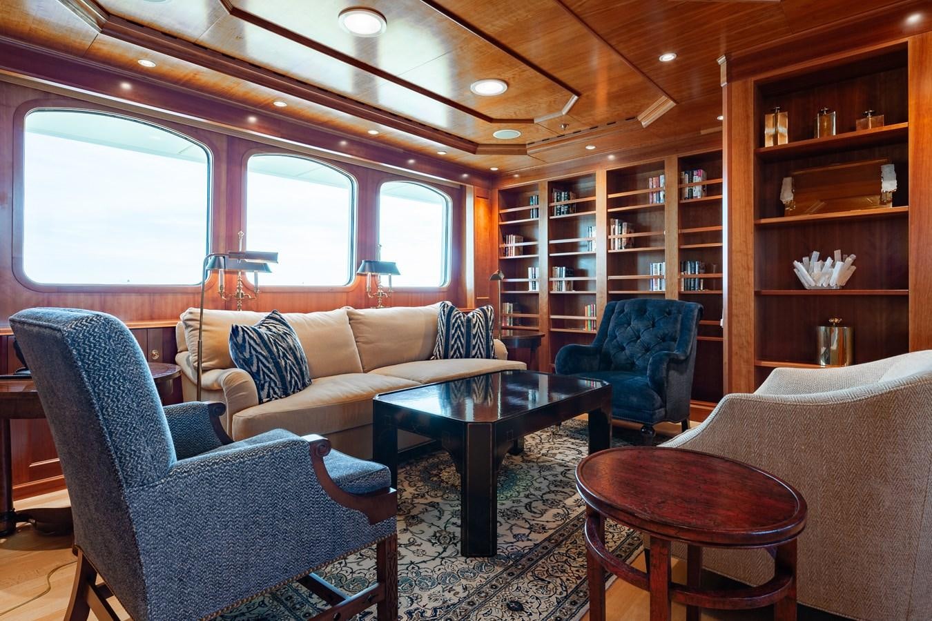 a living room with a blue chair and a table aboard CUPANI Yacht for Sale