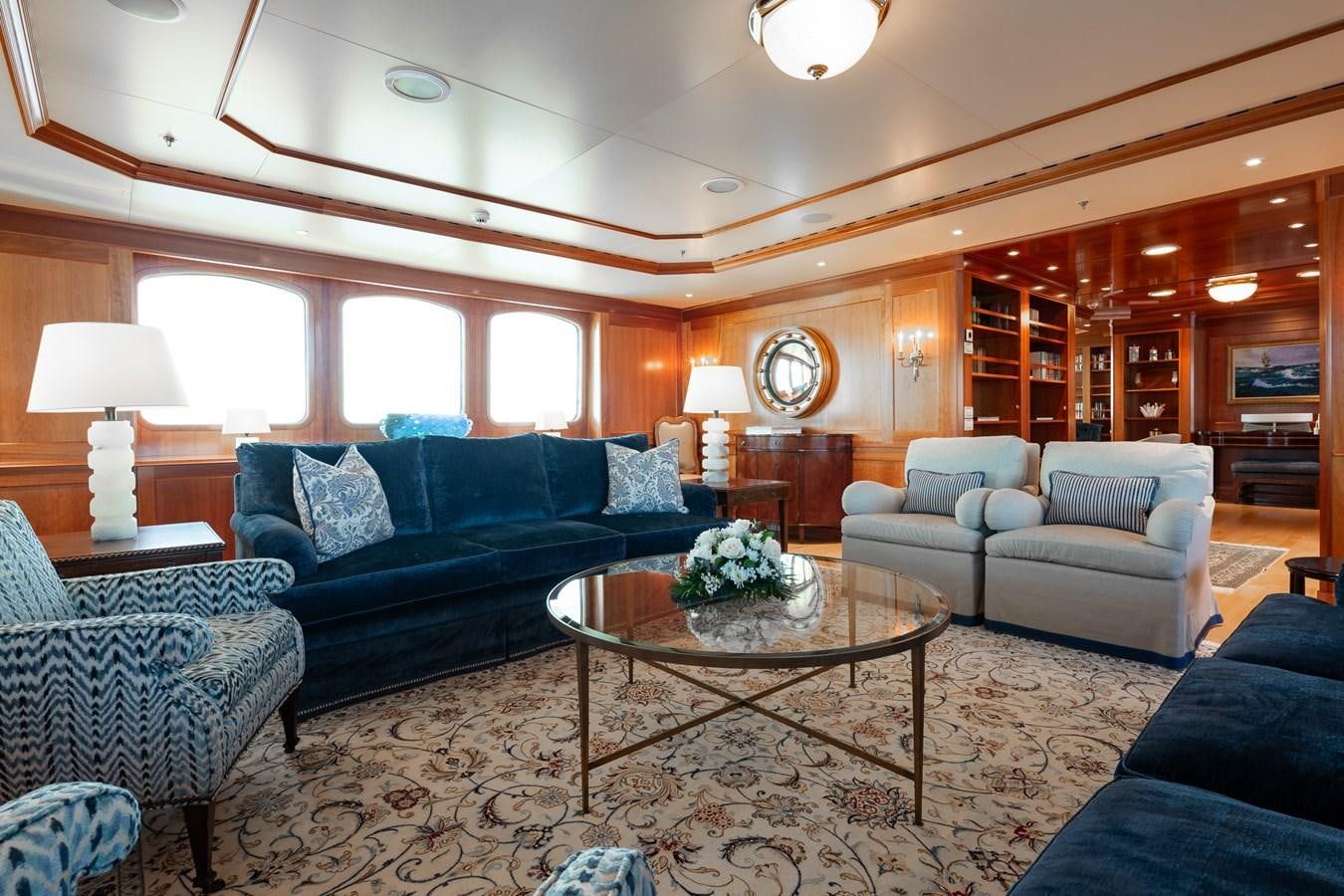 a living room with a blue couch and a coffee table aboard CUPANI Yacht for Sale