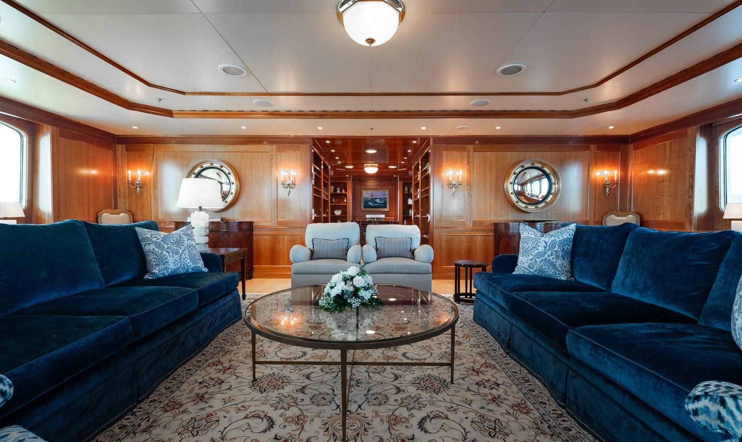 a living room with blue couches aboard CUPANI Yacht for Sale