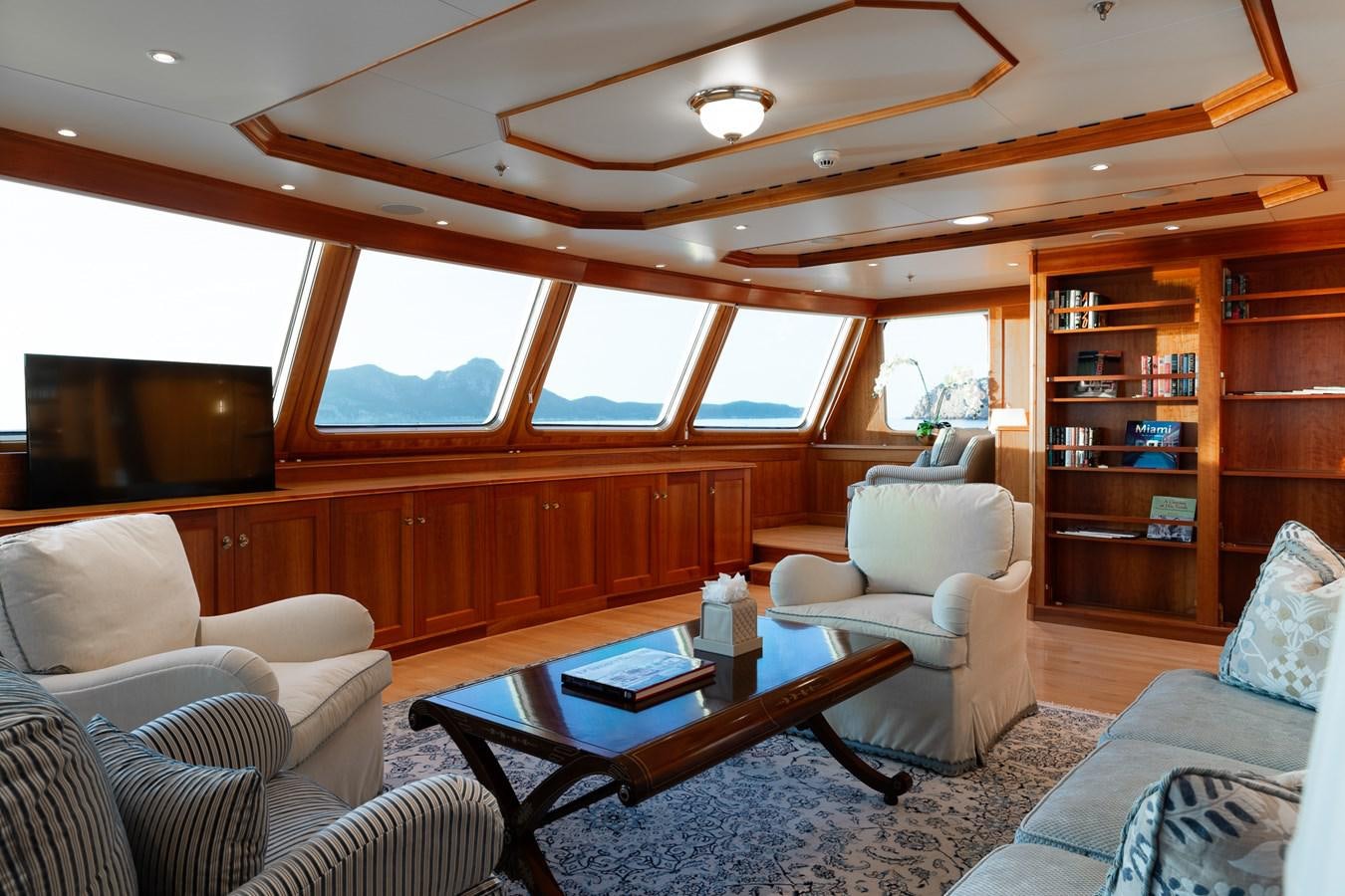 a living room with a book shelf aboard CUPANI Yacht for Sale