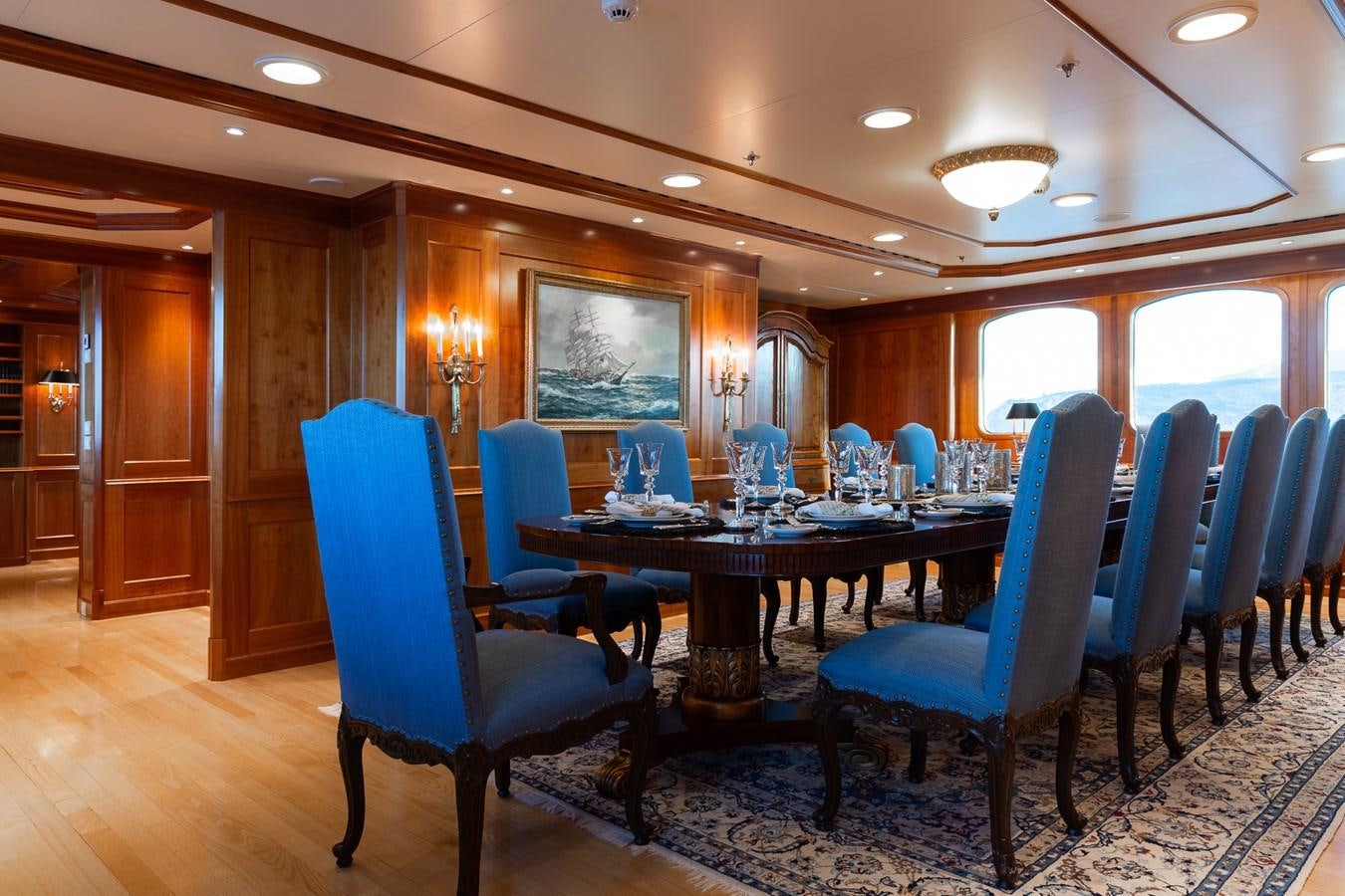 a dining room with blue chairs aboard CUPANI Yacht for Sale