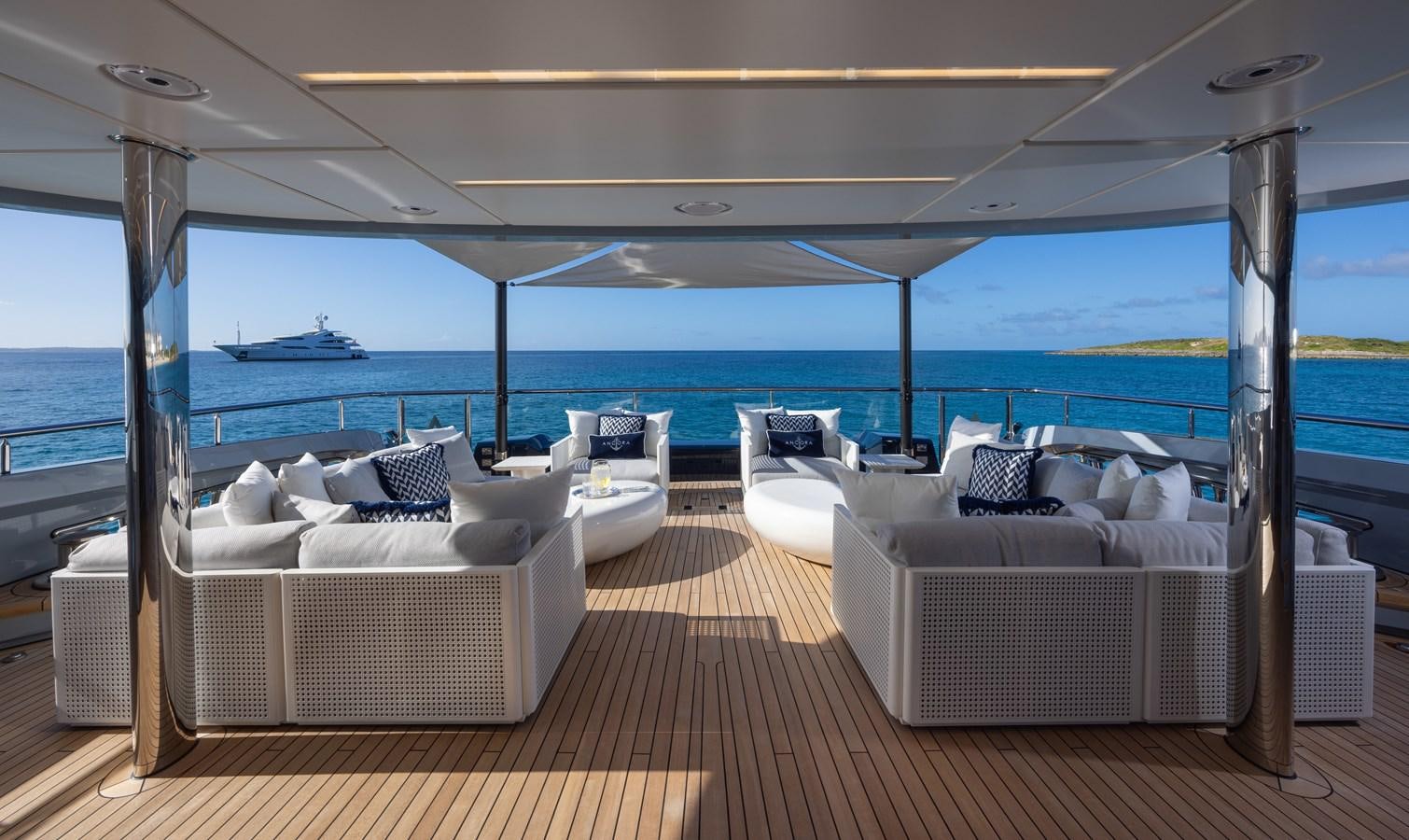 a room with a deck and chairs aboard ANCORA Yacht for Sale