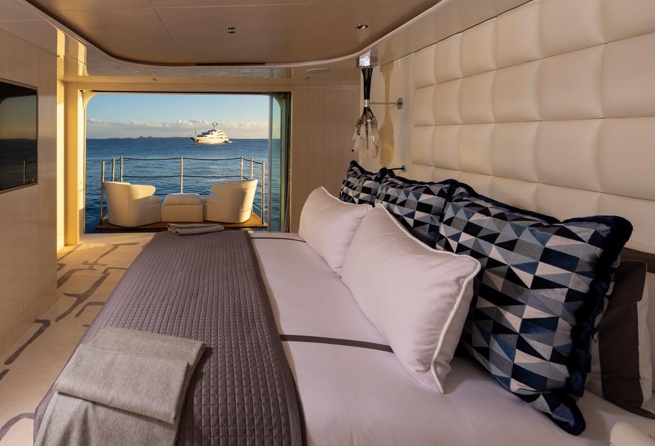 a bed with pillows and a view of the ocean aboard ANCORA Yacht for Sale