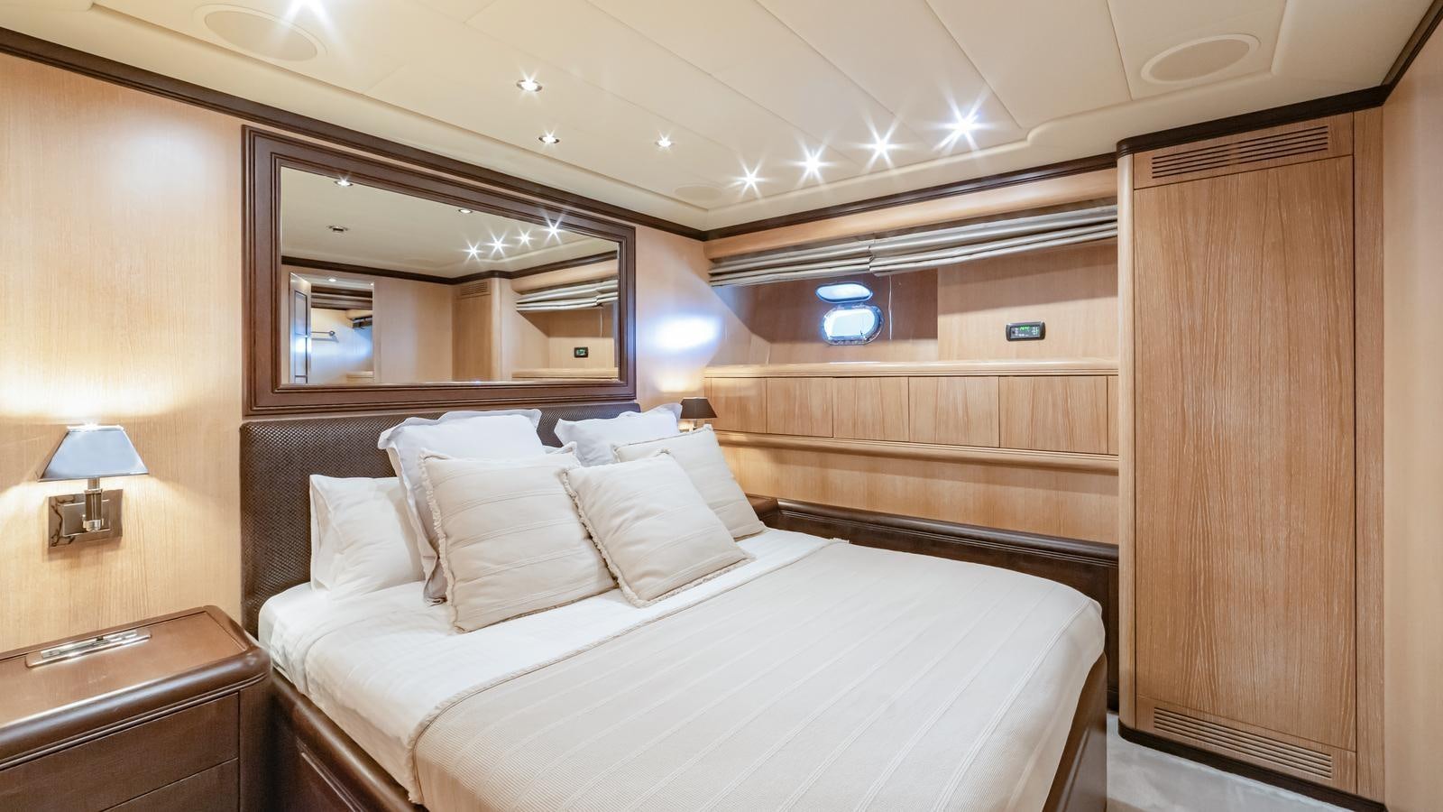 a room with a bed and a mirror aboard COSMOS Yacht for Sale
