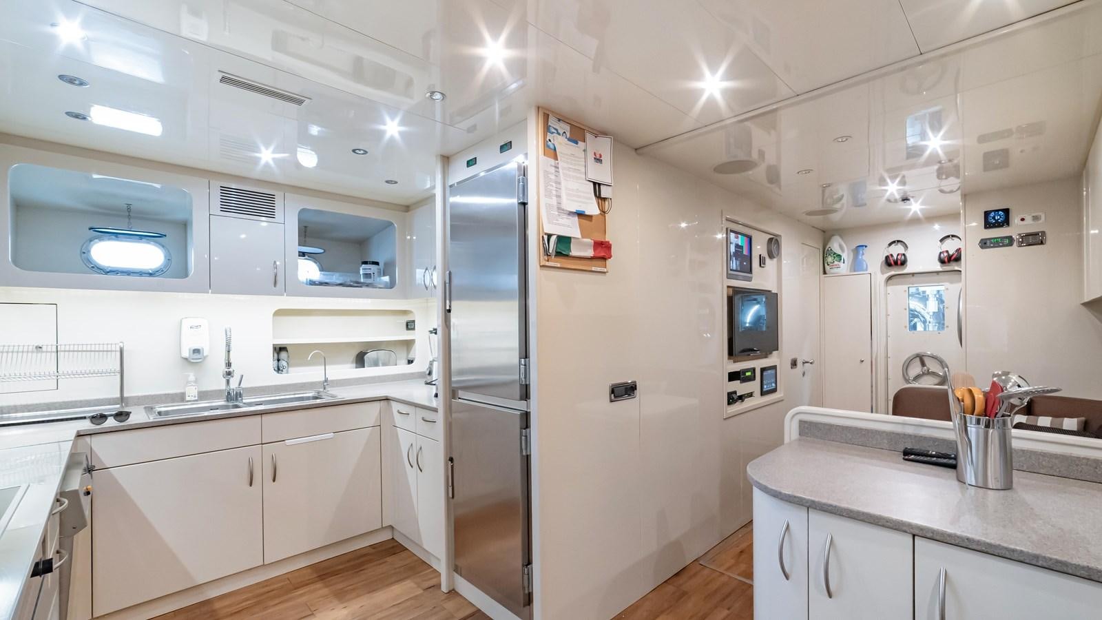 a kitchen with white cabinets aboard COSMOS Yacht for Sale