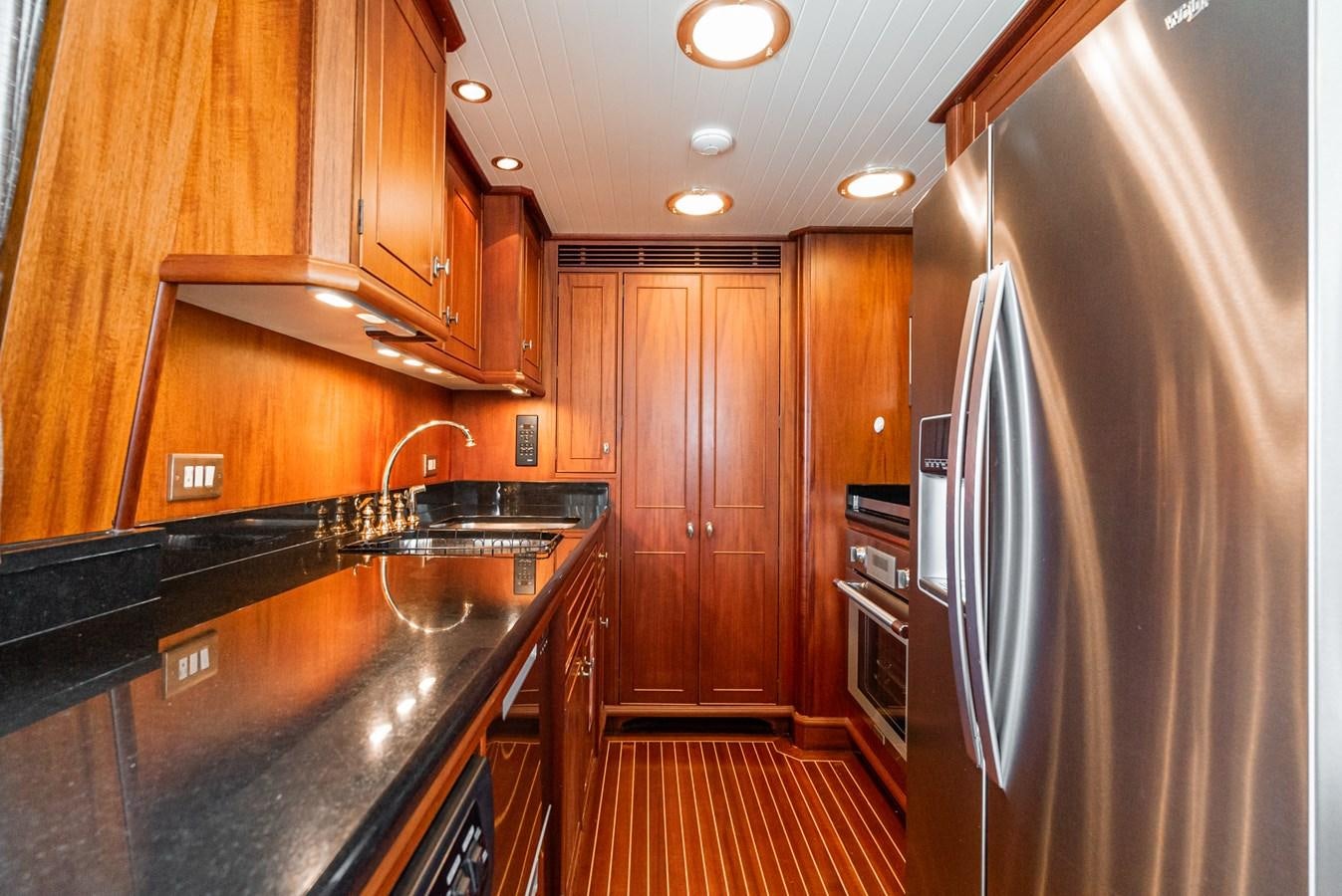 a kitchen with wooden cabinets aboard NIRVANA Yacht for Sale