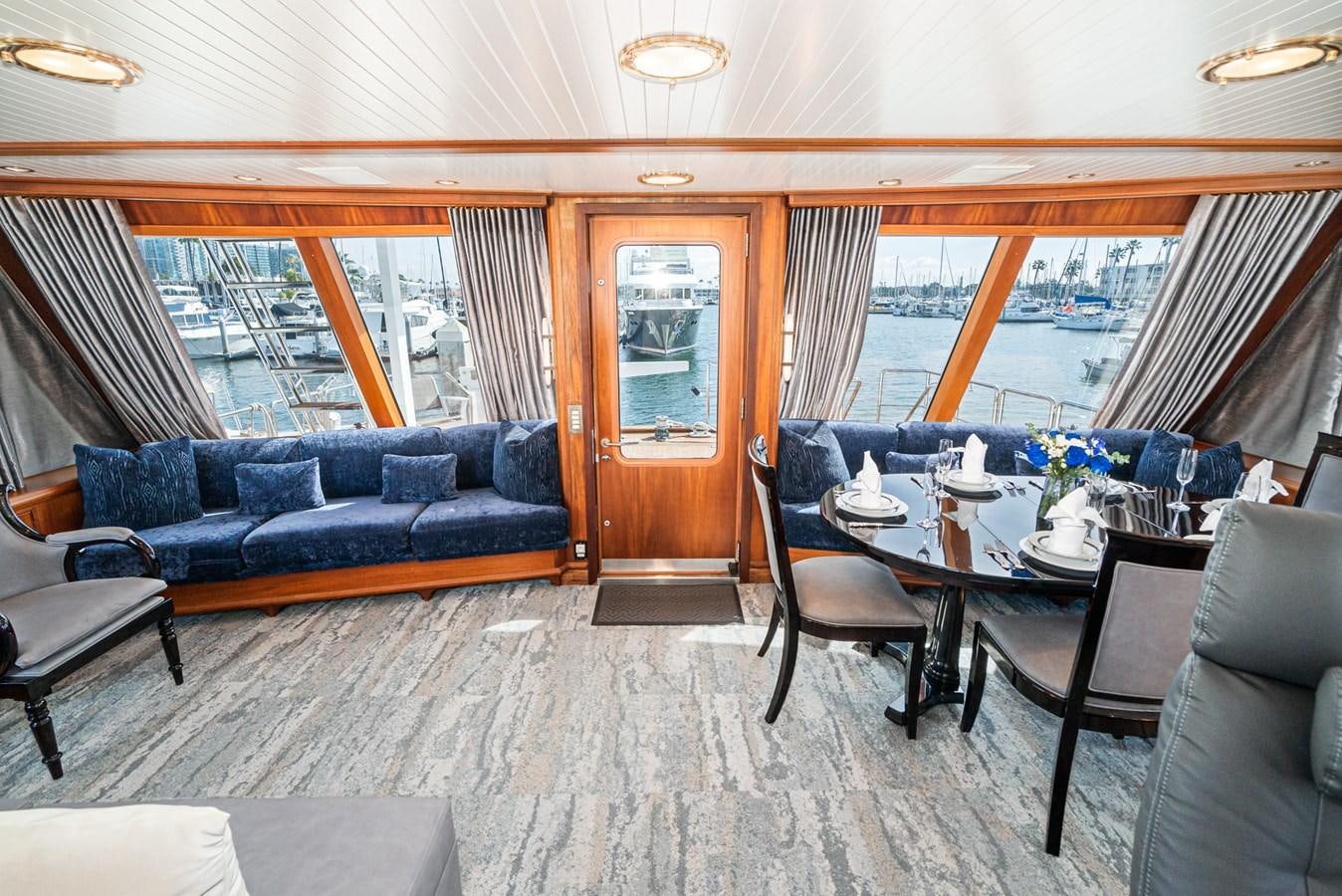 a living room with a blue couch and a table aboard NIRVANA Yacht for Sale