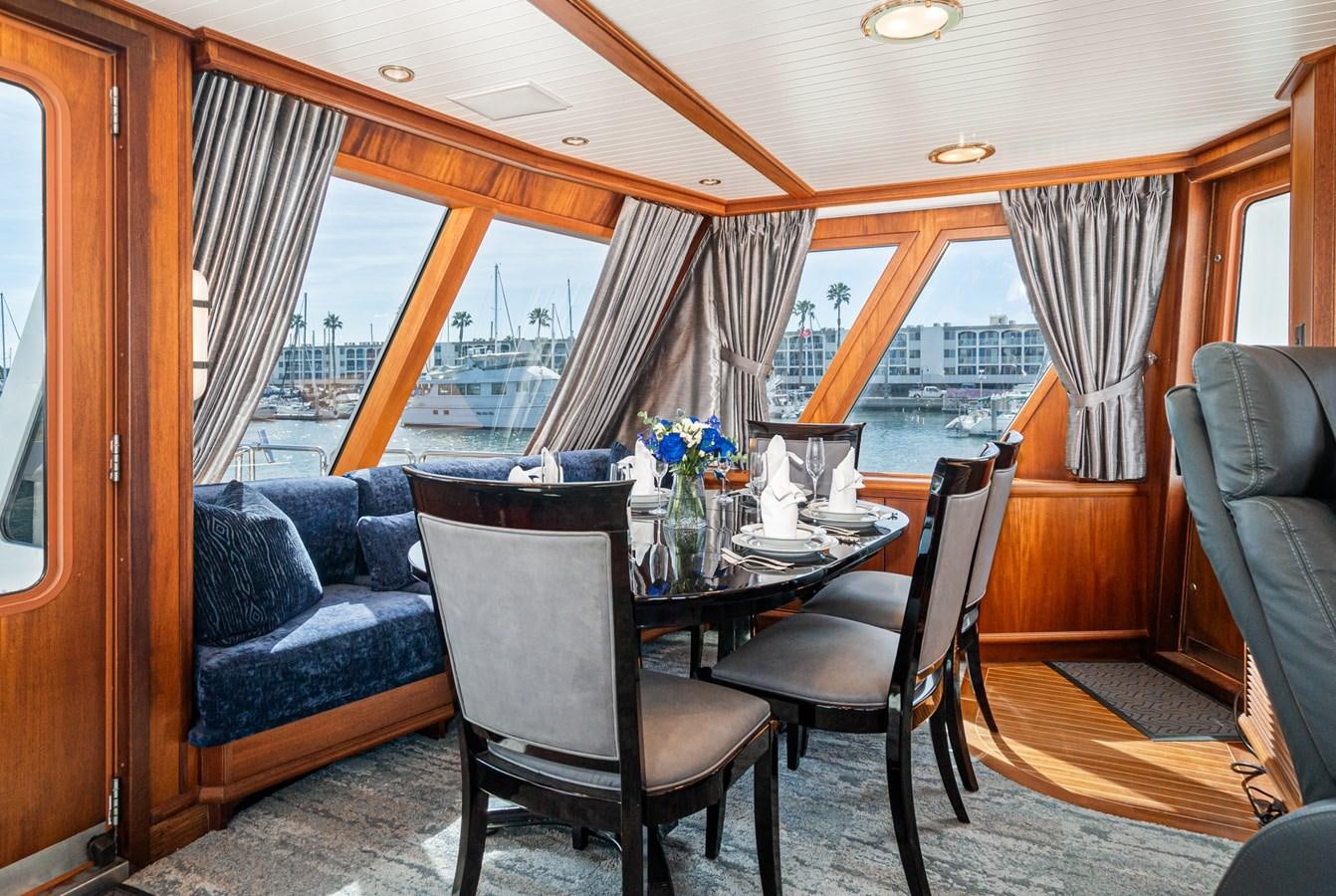 a dining table and chairs in a room with a view of the ocean aboard NIRVANA Yacht for Sale
