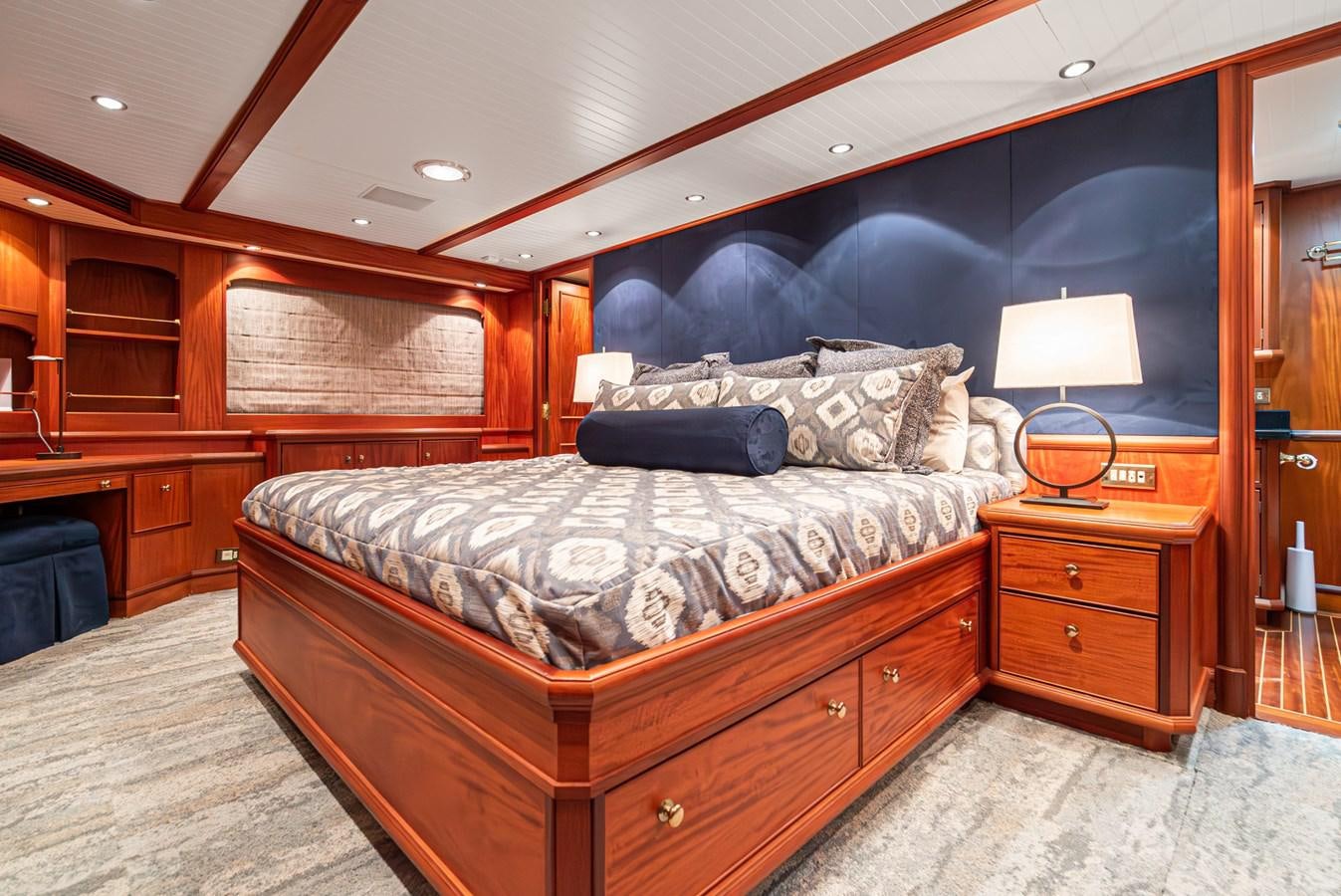 a bedroom with a bed and a lamp aboard NIRVANA Yacht for Sale