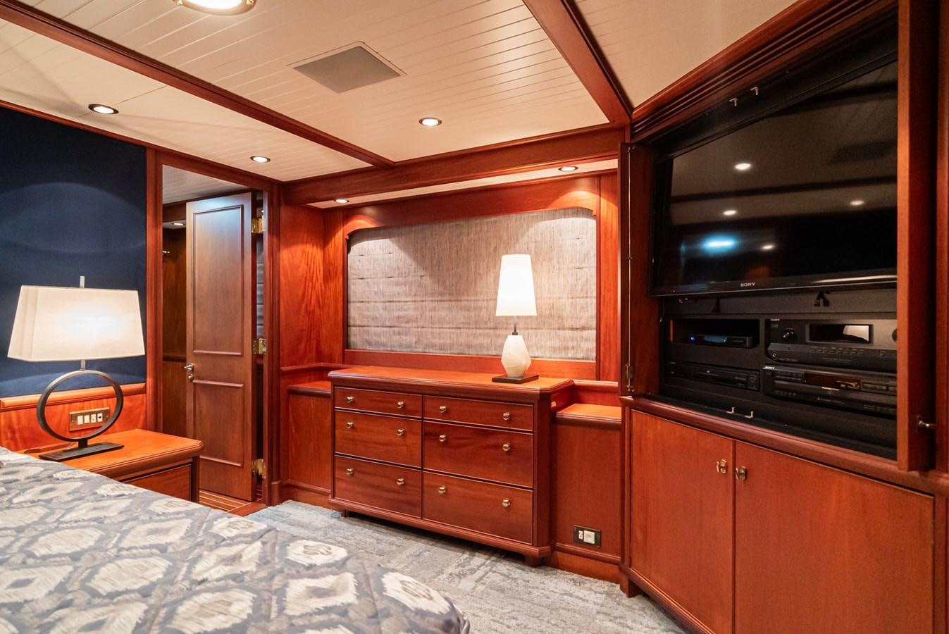 a bedroom with a bed and a dresser aboard NIRVANA Yacht for Sale