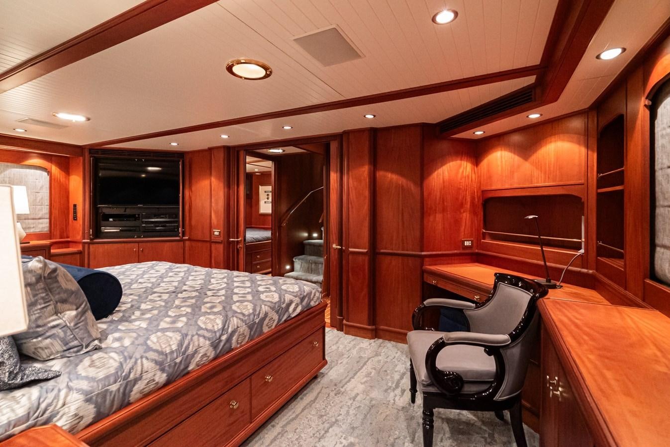 a bedroom with a bed and a chair aboard NIRVANA Yacht for Sale