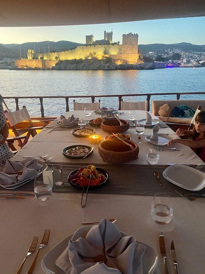 a table with plates and glasses on it aboard QUEEN OF DATCA Yacht for Sale