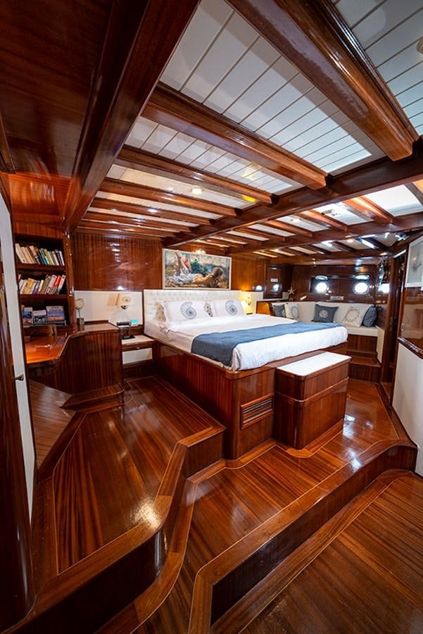 a room with wooden floors and a large bed aboard QUEEN OF DATCA Yacht for Sale