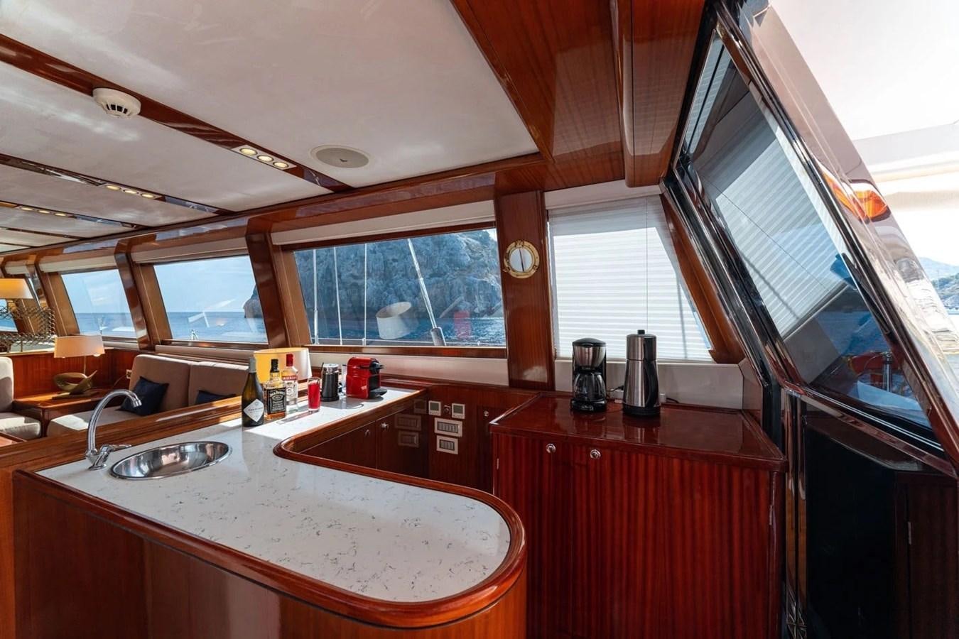 a kitchen with a large window aboard CUSTOM MOTORSAILOR Yacht for Sale